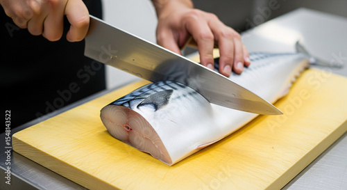 A chef cut a big piece of mackerel fillet on a wooden cutting board	