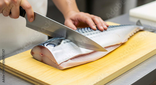 A chef cut a big piece of mackerel fillet on a wooden cutting board	