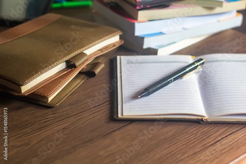 Several stacks of books and pencils are on the wooden table, education concept