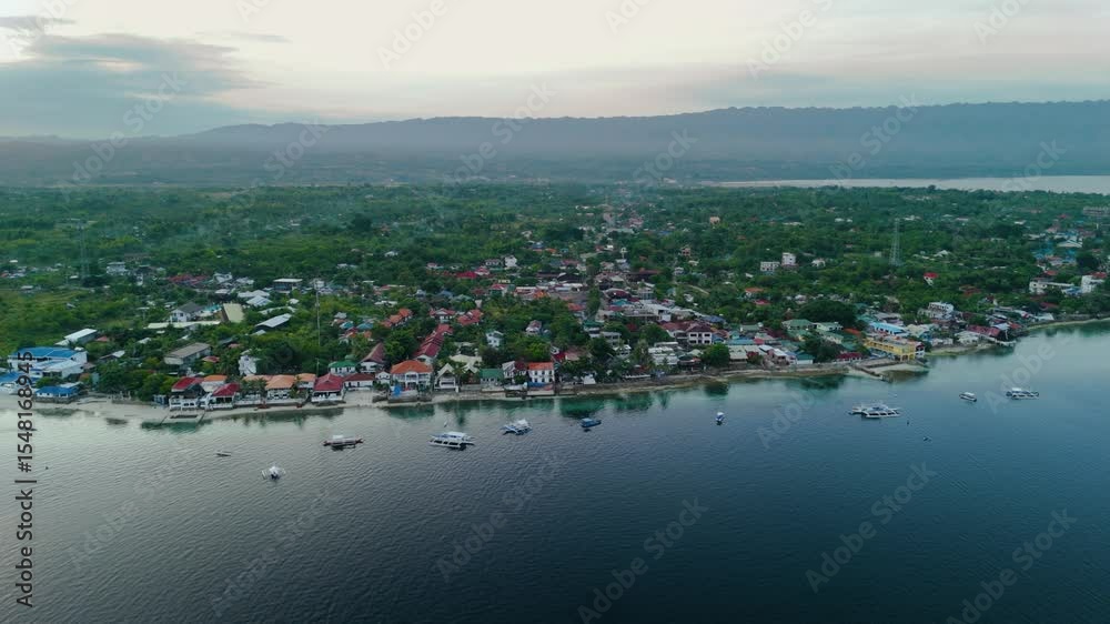 Scenic Shoreline and Bay coastline Aerial Panorama with bangka boats and Waterfront Homes of Moalboal beach in Moalboal, Cebu, Philippines Scenic Shoreline and Bay coastline Aerial Panorama with bangka boats and Waterfront Homes of Moalboal beach in Moalboal, Cebu, Philippines