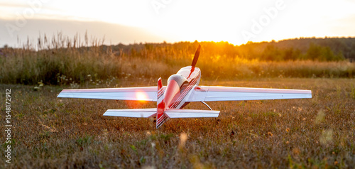 Model of an airplane on a field during sunset