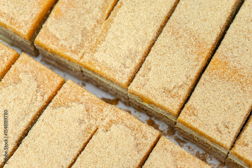 Traditional Portuguese biscuit cake slices on a white plate. A layered no-bake dessert made with Maria biscuits and creamy butter filling.