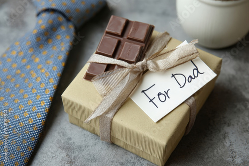 Father?s day gift box flatlay with necktie, chocolate bar, and handwritten note