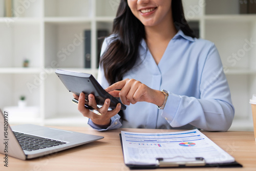 Female employee holding a calculator checking and calculating accounts