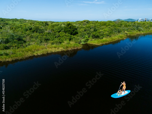 Happy mother with child have a fun on stand up paddle SUP board in sea lagoon. Healthy lifestyle. Recreational water sport, SUP tour in adventure camp on family summer beach vacation