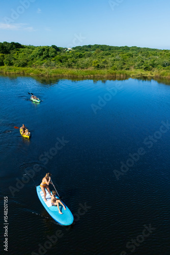 Active kids have a fun on kayak and stand up paddle SUP board in sea lagoon. Healthy lifestyle. Recreational water sport, SUP tour in adventure camp on family summer beach vacation