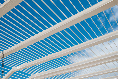 White steel beams and blue sky creating modern architectural design