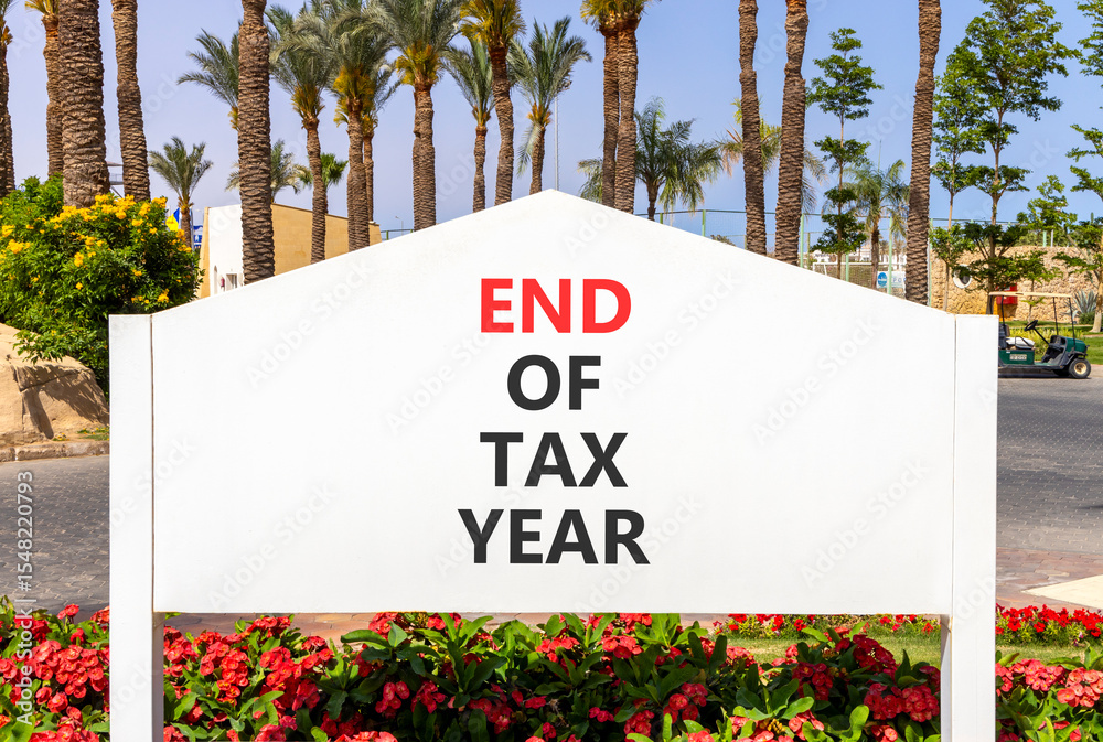 End of tax year symbol. Concept words phrase End of tax year on beautiful big white road sign. Beautiful palm tree blue sky background. Business End of tax year concept. Copy space.