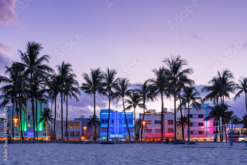 Colorful Art Deco hotels on Ocean Drive in Miami Beach glow under the warm hues of a vibrant sunset