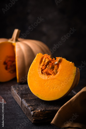 Raw fresh cut pumpkin on dark background