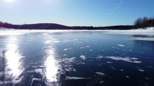 Scenic aerial view of partially frozen lake on a bright winter day landscape