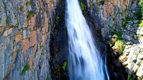 Majestic Waterfall Cascading Down Rocky Cliffs on a Sunny Day, Scenic Beauty