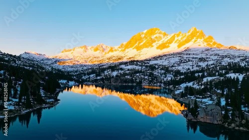 Majestic mountain range reflecting in lake at sunrise with snowy peaks