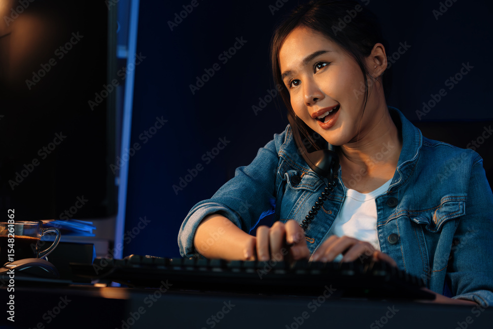 Young beautiful Asian creative woman calling on phone desk to customer or coworker explaining creator project's high profit while searching market analysis on pc at neon office at night. Stratagem. Young beautiful Asian creative woman calling on phone desk to customer or coworker explaining creator project's high profit while searching market analysis on pc at neon office at night. Stratagem.