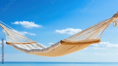 Relaxing white hammock swaying gently over a blue ocean under a clear sky