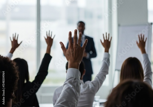 Business training seminar conference with audience raising hands for question and answer session in office space