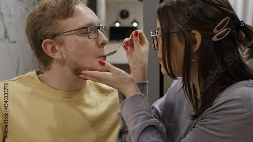 Charming and delightful couple joyfully shares playful moments together, enjoying delicious treats while demonstrating their deep affection and connection in a cozy indoor setting that exudes warmth