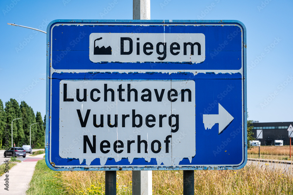 Fototapeta premium Road sign to the airport, Buurberg, Neerhof and industrial zone of Diegem Machelen, Flanders, Belgium
