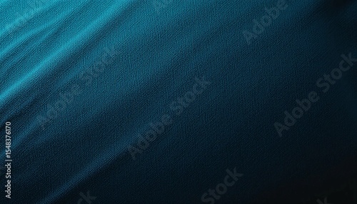 Close up of a textured blue fabric with soft shadows creating a wavy pattern