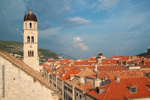Wallpaper Mural Architectural cityscape featuring a prominent bell tower with tiled rooftops under a bright sky Torontodigital.ca