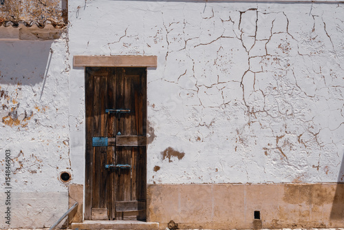 Well worn door and cracked plaster wall in Vila Real do Santo Domingo, Portugal