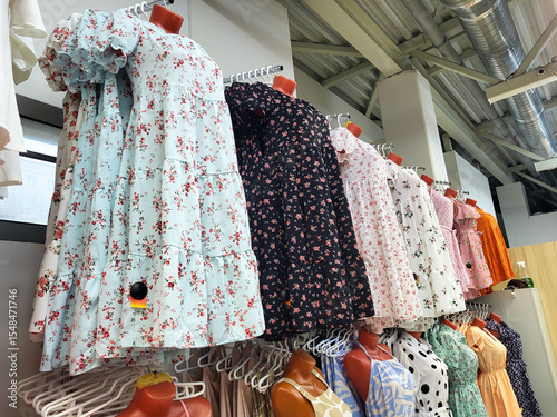 Beautiful summer bright stylish dresses hanging on a hanger show off a modern fashion collection. Conceptual fashion clothing