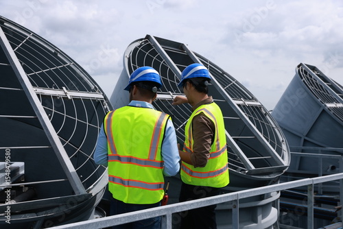 Mechanical engineer or industrial engineer with safety PPE inspect and maintenance cooling tower of HVAC system , Heating Ventilation and Air conditioning
