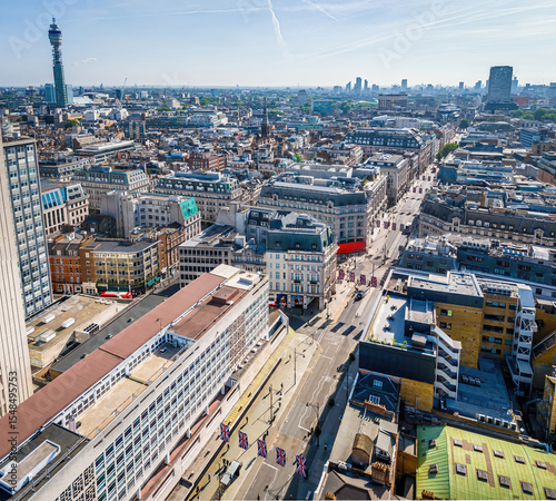 Aerial view of Oxford Circus in London with busy streets, iconic architecture, and red double-decker buses on a clear, sunny day