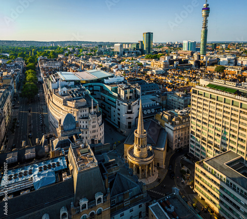 Aerial view of BBC Broadcasting House in London with the iconic All Souls Church and surrounding cityscape on a bright, clear day.