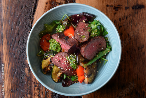 Εκτύπωση καμβά Bowl with warm sliced roast beef and grilled vegetables salad on wooden table