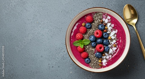 Indulge in this vibrant berry smoothie bowl, a delightful blend of fresh raspberries, blueberries, chia seeds, and shredded coconut, perfect for a healthy and delicious breakfast or snack.