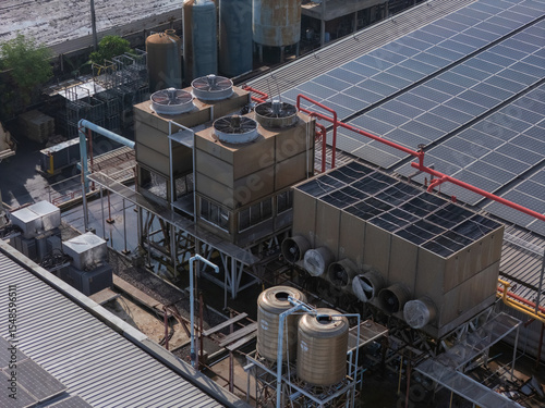 Cooling towers in data center building. Air conditioning cooling towers in front of building with fins to the front. Industrial cooling towers or air cooled water chillers with piping system.