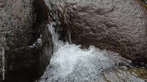 Close up of clear water flowing between rocks in the river.