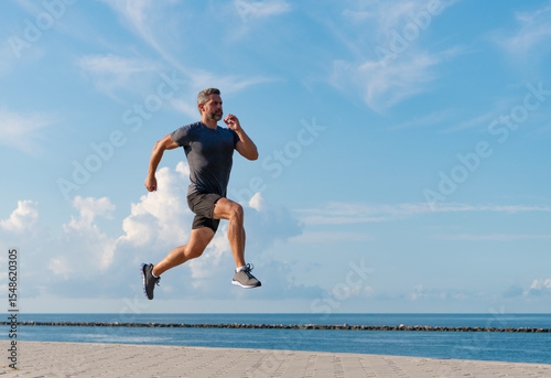 Sportsman running in summer. Sport runner training outdoor. Healthy lifestyle with daily run. Runner man running. Fitness and sport. Man running at beach. Sport lifestyle. Copy space banner