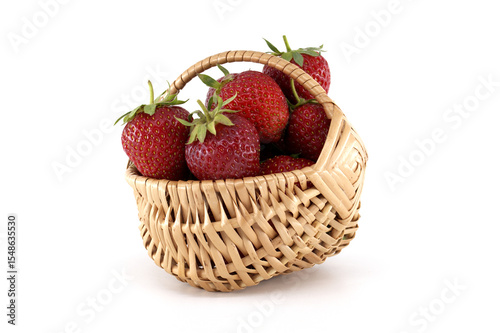 Fresh strawberries overflowing a small wicker basket