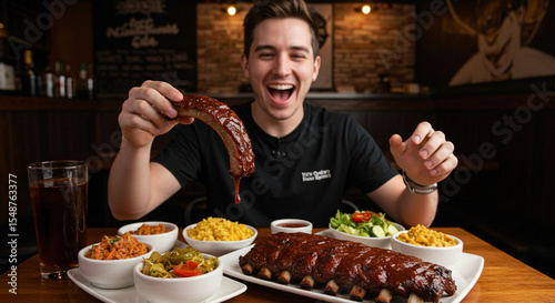 Food vlogger leaning over a table full of BBQ ribs and sides, holding one saucy rib up towards the camera