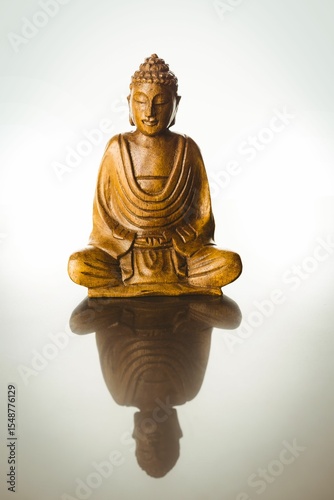 Buddha statue with reflection on table
