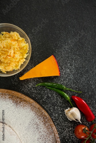 Cheese by spices on black table