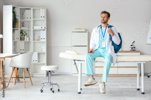 Young male doctor in scrubs...