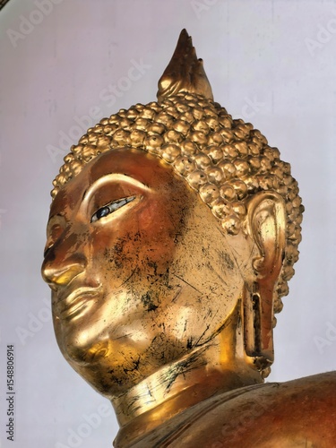 Close-up of a golden Buddha statue with serene expression