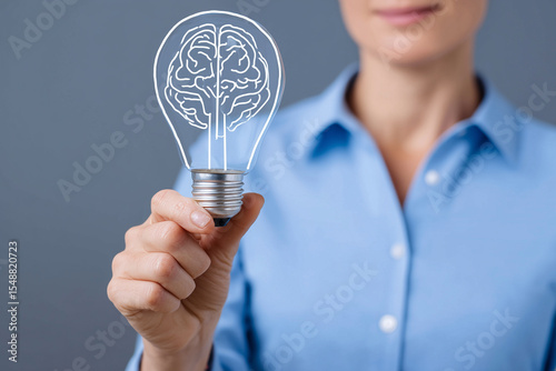womans hand holding glowing brain-shaped lightbulb, neural thinking and futuristic creativity, stock photo style