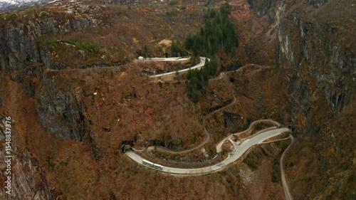 Intricate serpentine road leads to Voringsfossen waterfall. Part of highway between tunnels through rugged mountains. Challenging terrain in Norway