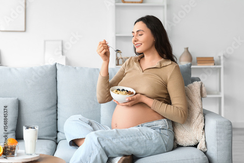 Young pregnant woman eating...