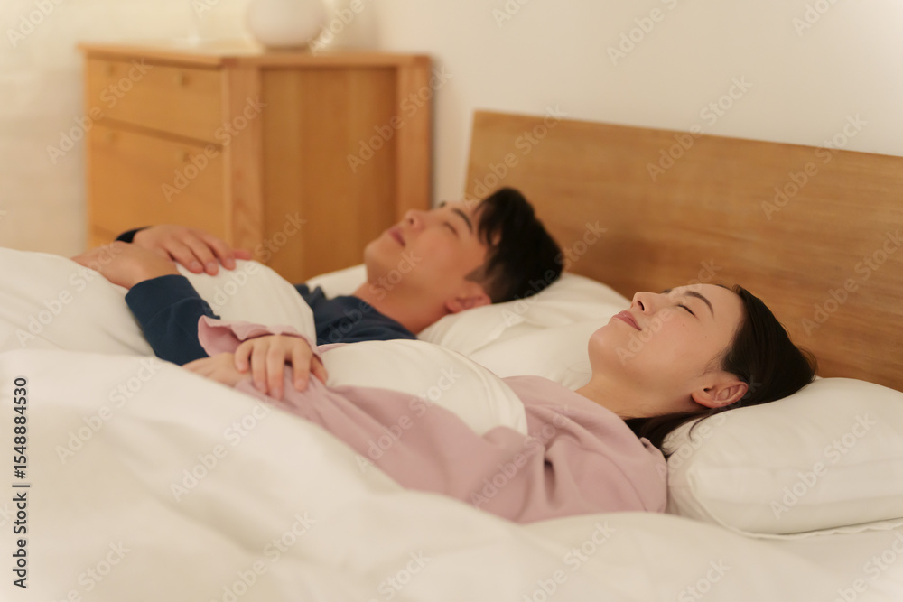 Fototapeta premium ダブルベッドで一緒に寝る夫婦