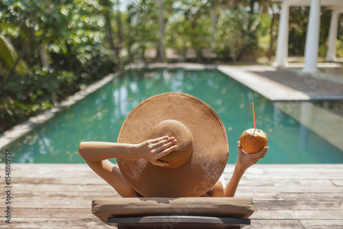 Photography Woman Relaxing by Pool with Sun Hat and Coconut
