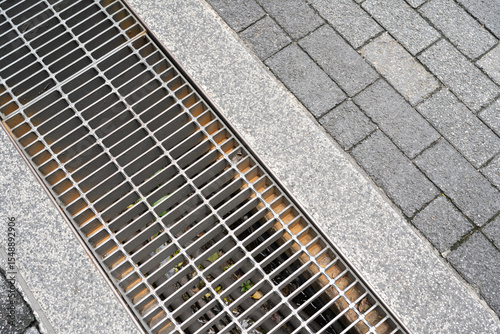 Urban Drainage Grate and Paving Stones. street and sidewalk design for water management and pedestrian areas.