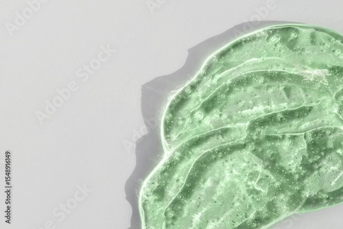 Green cosmetic smear gel texture on a white background
