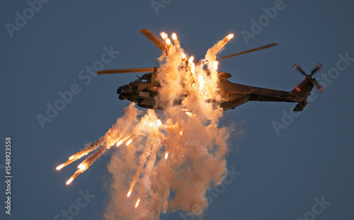 Modern military helicopter during a defensive maneuver,firing flares