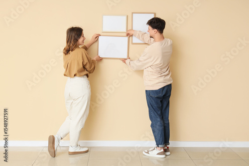 Young couple hanging blank ...