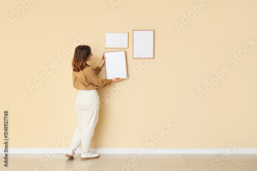 Young woman hanging blank f...